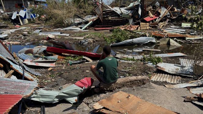 Un jeune homme se tient près des ruines de sa maison, ravagée par le cyclone Chido, à Labattoir, à Mayotte, le 15 décembre.