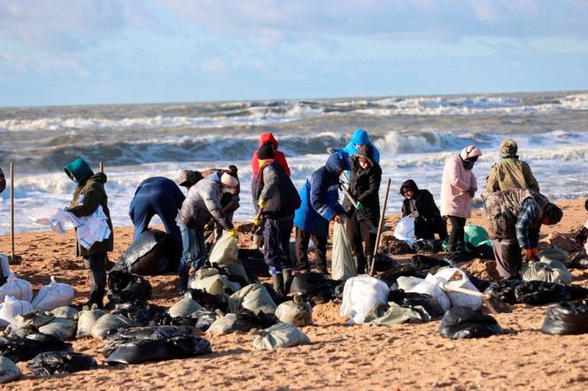 Voluntários limpam óleo derramado na costa após um incidente envolvendo dois petroleiros danificados em uma tempestade no Estreito de Kerch, no resort de Anapa, no Mar Negro, Rússia, em 18 de dezembro de 2024. 