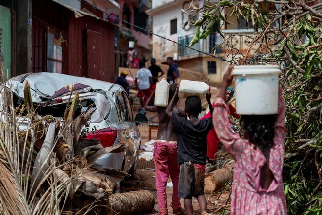 Crianças carregam recipientes de água em Mamoudzou, Mayotte, 18 de dezembro de 2024.