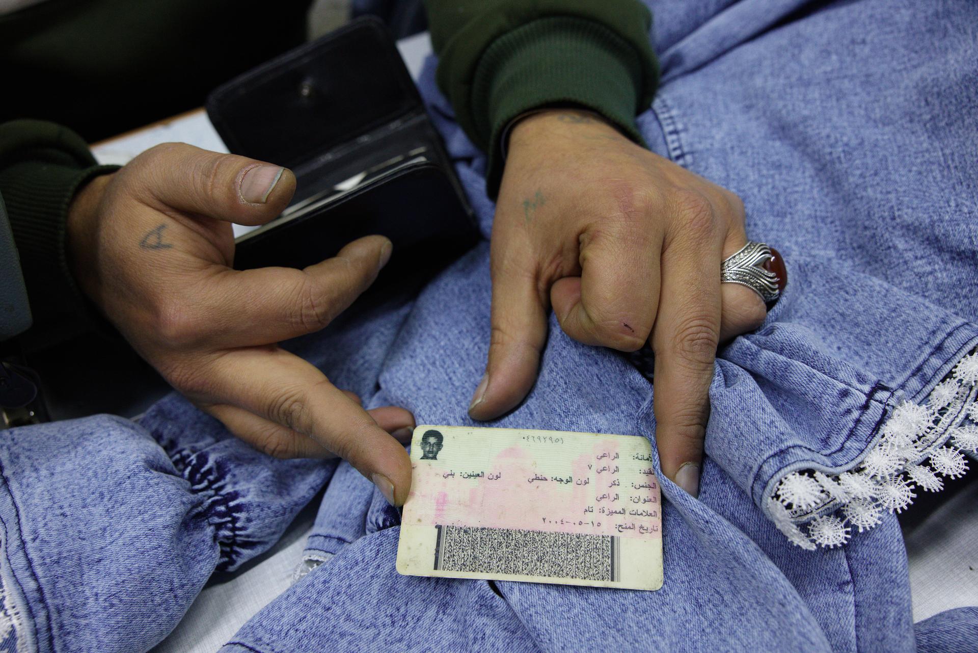 Yusuf shows his Syrian identity card. On the back, in the bottom right corner, two lines are written to identify Sunnis, one line for Alawites. In 2008, he was imprisoned in Saydnaya for 11 months because he is a Syrian Turkmen. In the Syrian neighborhood of Gümüştekin, in Gaziantep, Turkey, on 14 December 2024.