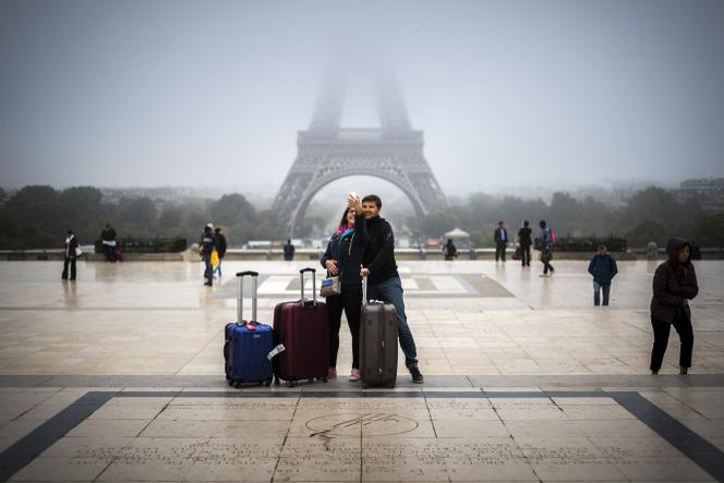 Des touristes devant la tour Eiffel, à Paris, le 26 octobre 2016.