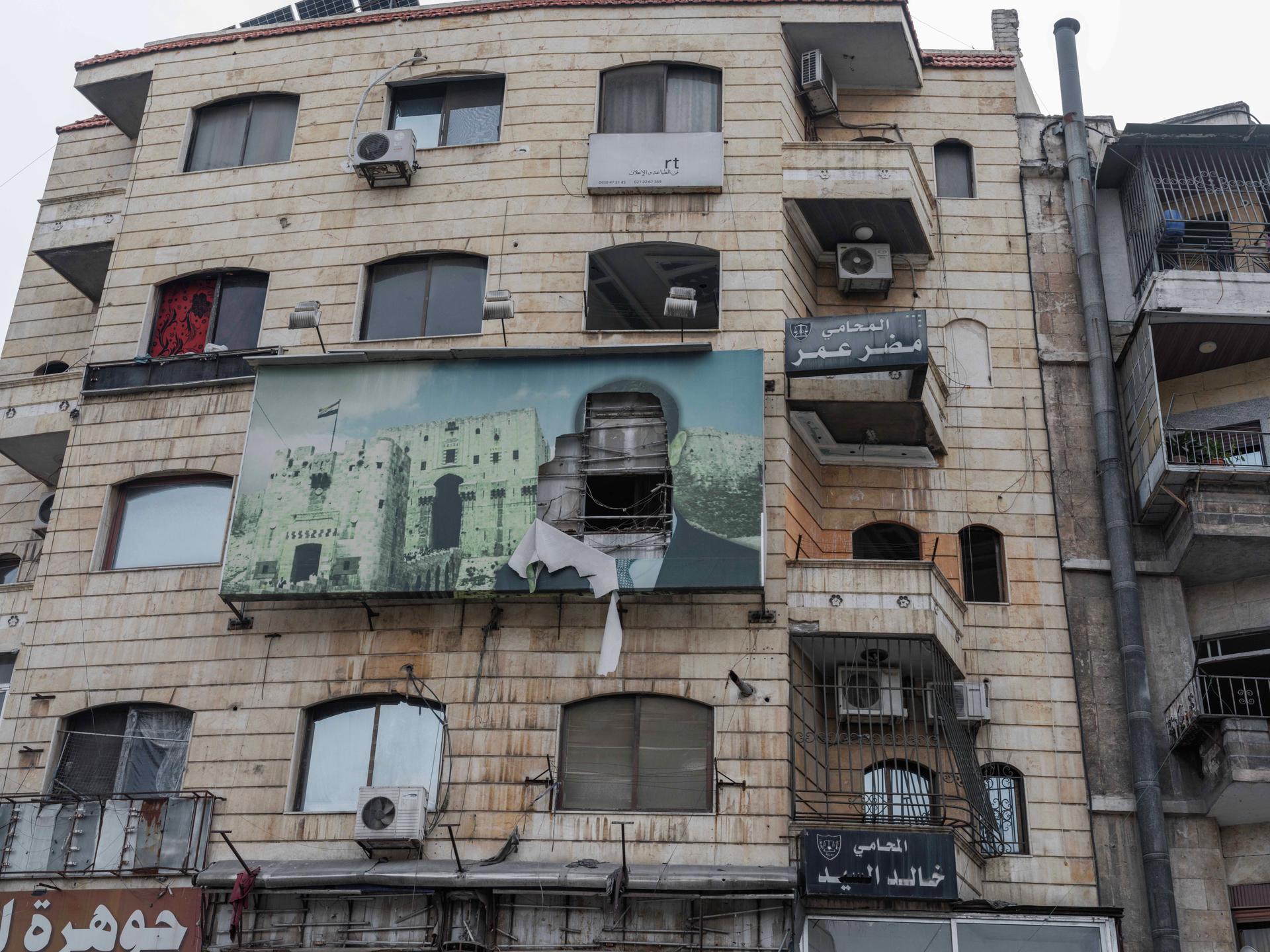 A torn portrait of former Syrian president Bashar al-Assad on the facade of a building in western Aleppo, Syria, December 20, 2024.