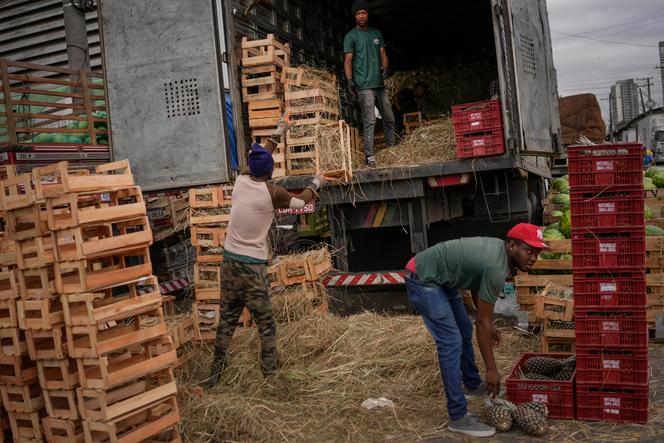 Des travailleurs déchargent un camion de fruits au marché de gros de Sao Paulo (Brésil), le 25 octobre 2022.