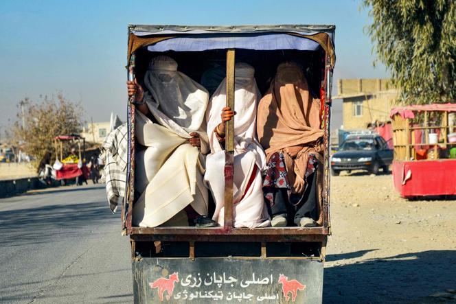 Mulheres afegãs usando burcas são transportadas na traseira de um veículo, em Kandahar, Afeganistão, 29 de dezembro de 2024.
