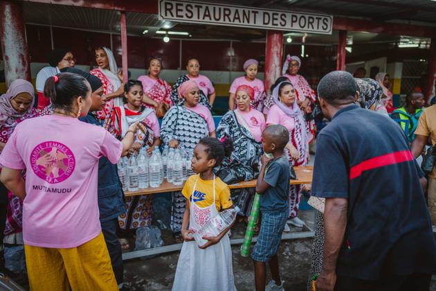 Des membres de l’association Solidarité femmes action distribuent de l’eau et des kits alimentaires aux personnes affectées par le cyclone Chido, au port de Mutsamudu, sur l’île comorienne d’Anjouan, le 25 décembre 2024.