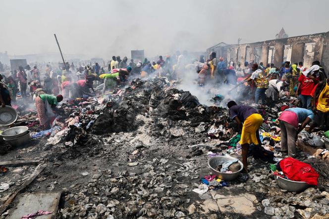 Des gens tentent de récupérer des vêtements sur le marché de Kantamanto ravagé par l'incendie à Accra, au Ghana, le 2 janvier 2025.