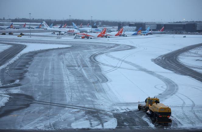 Un chasse-neige attend pour aider à dégager la neige autour des avions, à l’aéroport de Manchester, le 5 janvier 2025.