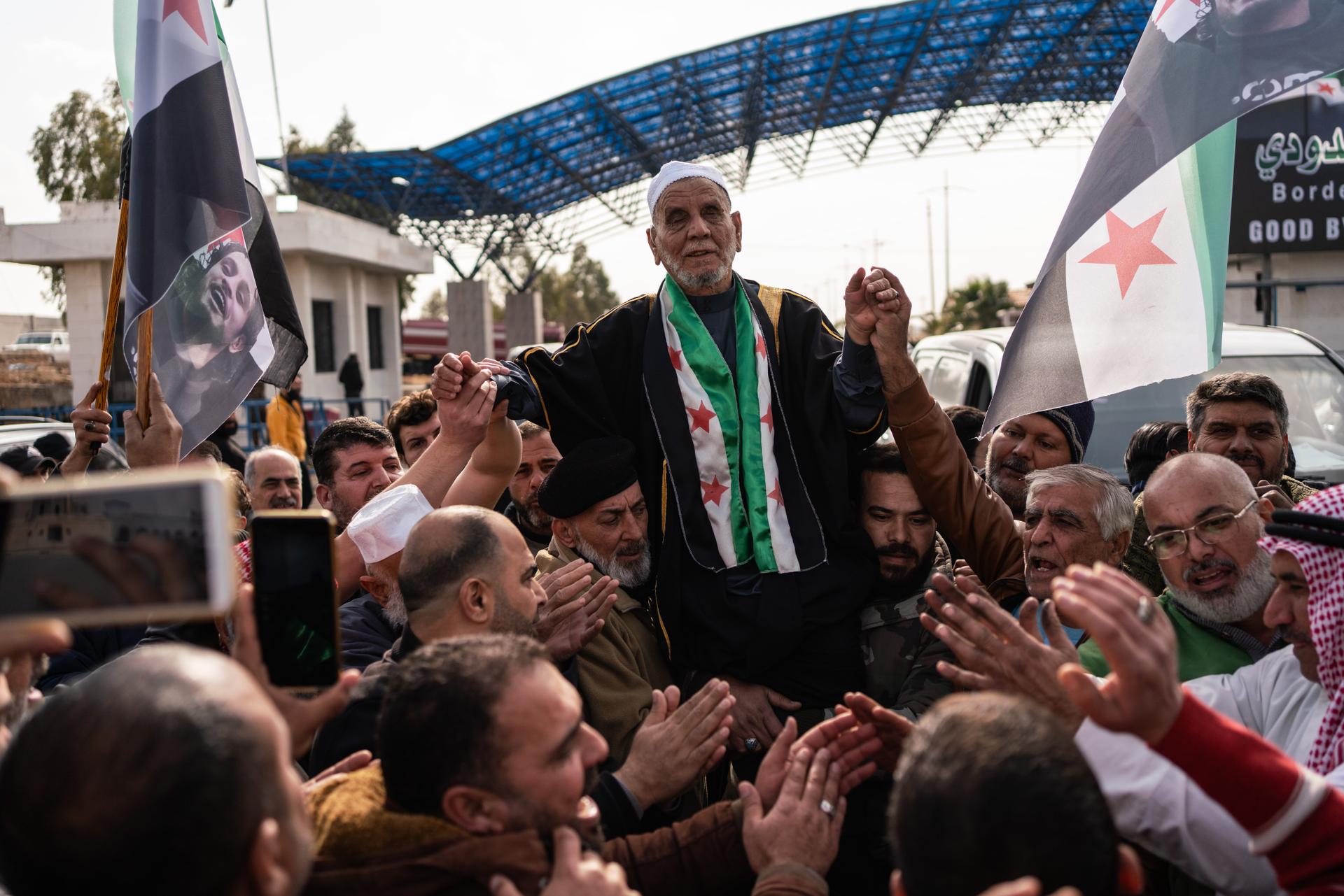 Sheikh Ahmad Al-Sayasna is carried on people's shoulders at the Nassib border crossing between Jordan and Syria as he returns to Syria after the fall of Bashar Al-Assad's regime on December 26, 2024.