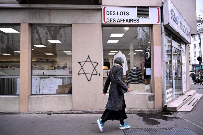 Une personne passe devant une étoile de David taguée la veille sur le mur extérieur d’un magasin à Vincennes, en banlieue parisienne, le 6 janvier 2025.