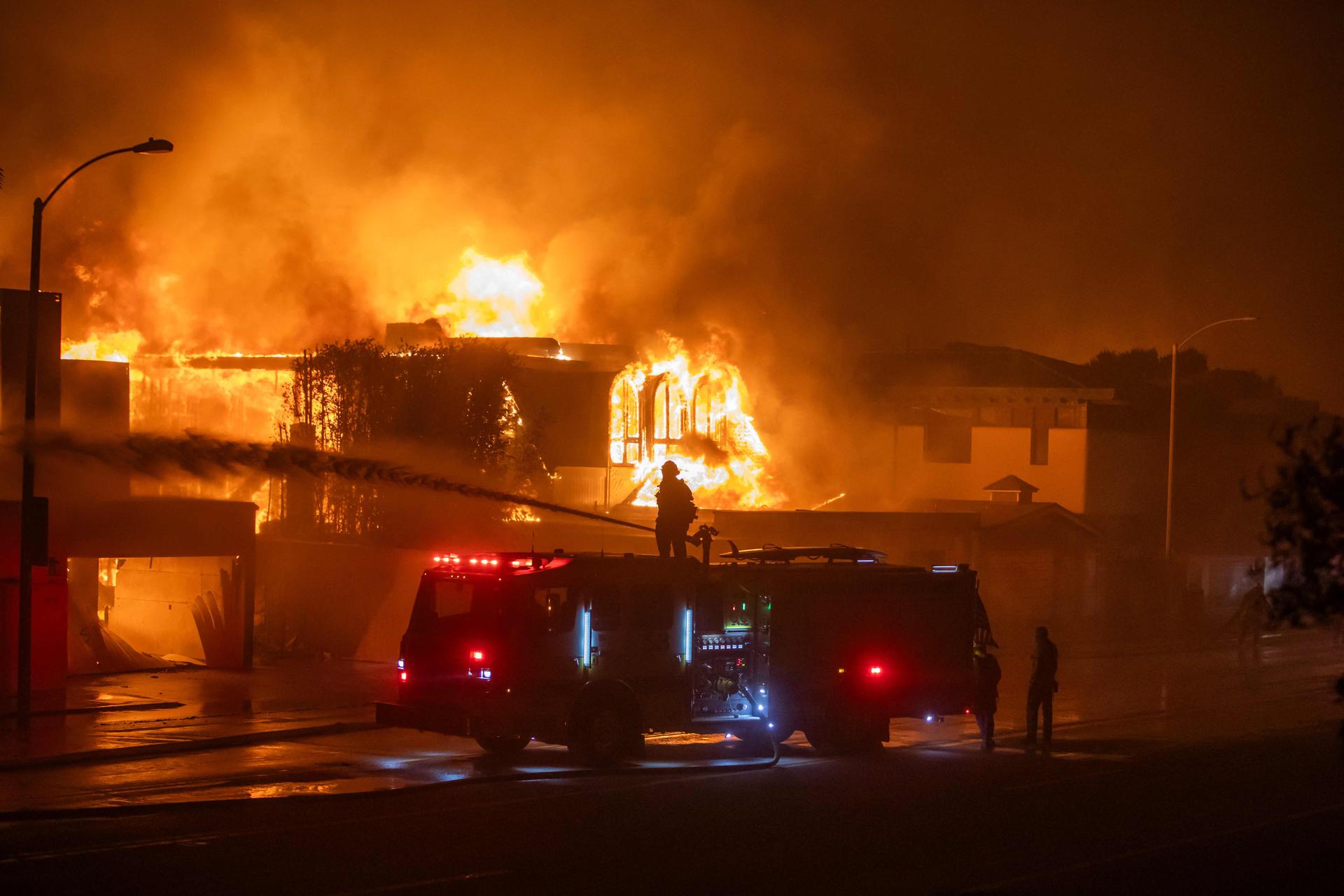 Des maisons en feu sur l’autoroute de la côte Pacifique, le 8 janvier 2025 à Los Angeles, en Californie. 