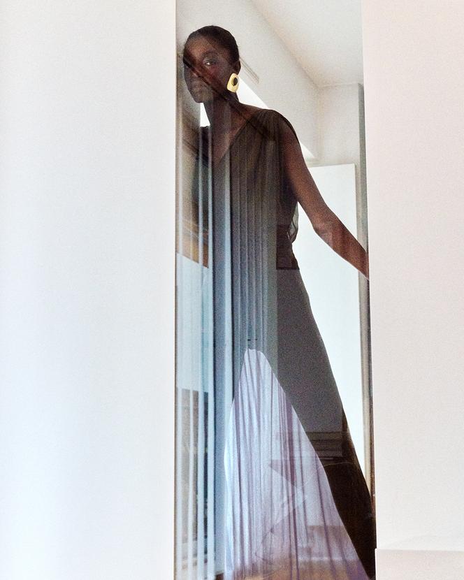 Robe longue smockée en crêpe de soie, prix sur demande, et boucle d’oreille Saint Laurent par Anthony Vaccarello. ysl.com