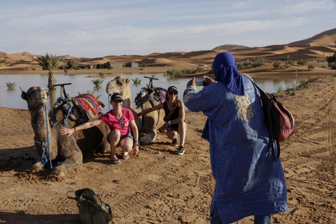 Des touristes au bord du lac saisonnier Yasmina, à côté du village de Merzouga dans le désert du Sahara au sud-est du Maroc, en octobre 2024.