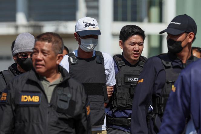 Ekkalak Paenoi est escorté par des officiers de police alors qu’il arrive en Thaïlande après avoir été transféré du Cambodge aux autorités thaïlandaises, à Bangkok, le 11 janvier 2025.