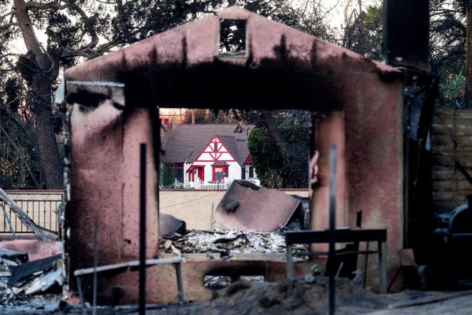 Casas em Altadena (Califórnia), uma destruída por um incêndio e outra poupada, em 13 de janeiro de 2025.