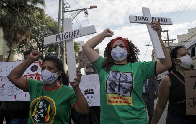 Une manifestante tient une croix portant le nom de Joao Pedro, 14 ans, tué lors d’une opération de police contre les gangs de la drogue dans le bidonville de Salgueiro, à Sao Gonçalo, près de Rio de Janeiro, au Brésil, le 5 juin 2020.
