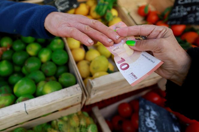 Um cliente paga com um bilhete de dez euros em um mercado em Aix-en-Provence, em 16 de janeiro de 2025. 