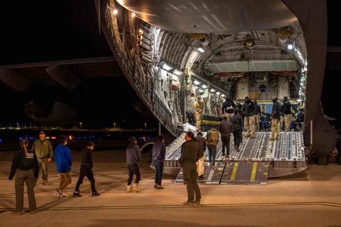 Des agents des douanes et de la protection des frontières des États-Unis guident des migrants sans papiers dans un avion de transport militaire, à l’aéroport international de Tucson, en Arizona, le 23 janvier 2025. Photo fournie par le ministère de la défense américain.