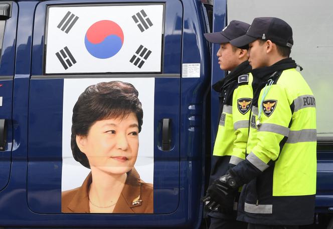 Des policiers devant un portrait de l’ancienne présidente sud-coréenne Park Geun-hye exposé par ses partisans devant le tribunal du district central de Séoul, à Séoul, le 6 avril 2018.