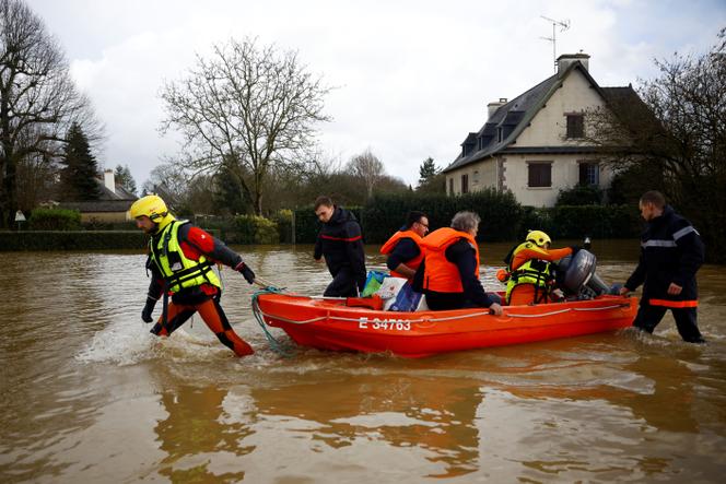 Des pompiers tirent un bateau avec des habitants dans une rue inondée à Guipry-Messac (Ille-et-Vilaine) alors que la Vilaine déborde après des jours de fortes pluies causant des inondations à la suite de la tempête Herminia, le 27 janvier 2025.