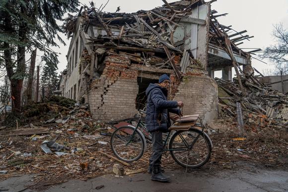 Mykola, 76 ans, attache du bois de chauffage sur son vélo devant un bâtiment partiellement détruit par les frappes militaires russes, dans le cadre de l’attaque de la Russie contre l’Ukraine, à Pokrovsk, dans l’oblast de Donetsk, le 25 janvier 2025.