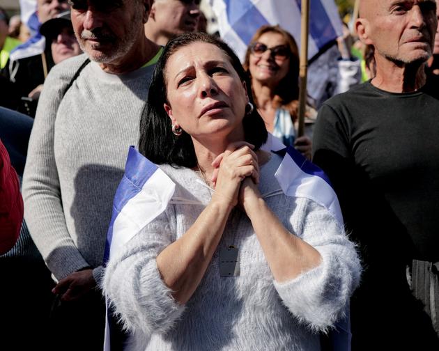 Une femme prie dans la foule face à l’écran qui retransmet la libération des trois otages israéliens sur la place des otages de Tel-Aviv en Israel le 8 février 2025. 
