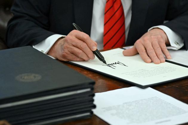 US President Donald Trump signs an executive order at the White House in Washington on February 10, 2025.