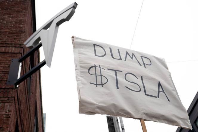 Un manifestant tient une pancarte appelant les actionnaires à vendre leurs actions Tesla, à Seattle (Washington), le 15 février 2025.