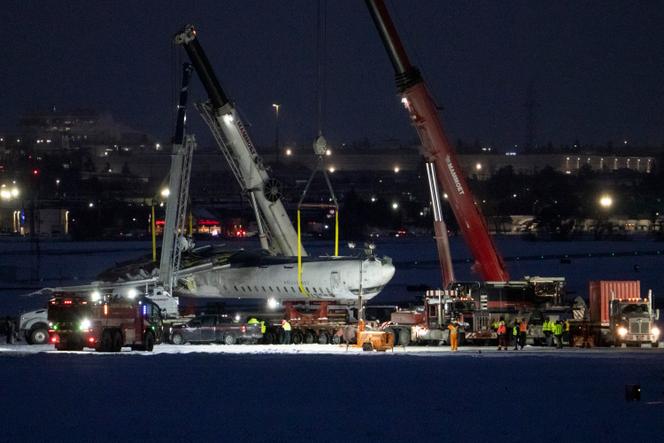 Des grues soulèvent l’épave du vol Delta 4819 de la piste de l’aéroport international Pearson de Toronto, à Mississauga (Ontario), le mercredi 19 février 2025. 