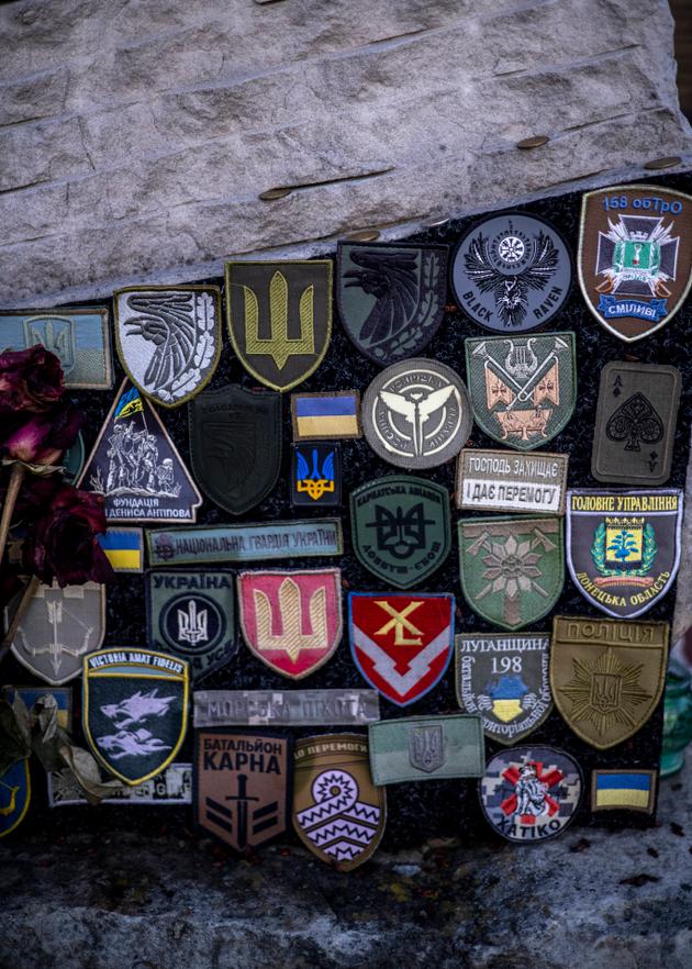 Military badges displayed on a stele commemorating fallen soldiers in the Cherkasy region of Ukraine, February 13, 2025.