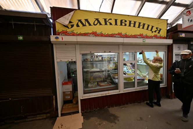 Une vendeuse ouvre son kiosque sur le marché rouvert de Bucha, dans la région de Kiev, le 22 mai 2022.