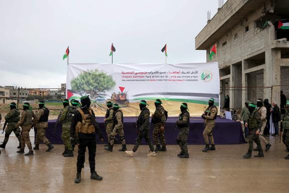 Des combattants du Hamas se rassemblent sur le site de la remise des otages israéliens dans le camp de réfugiés de Nuseirat, dans le centre de la bande de Gaza, dans le cadre de la septième libération d’otages, samedi 22 février 2025.