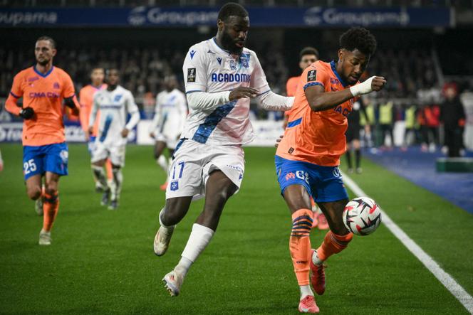 لاعب مارسيليا أمير موريي (إلى اليمين) واللاعب الأكسيروي لاسيني سينايوكو (في المنتصف) خلال مباراتهم في استاد أبي-ديشامب، في أكسير، 22 فبراير 2025.