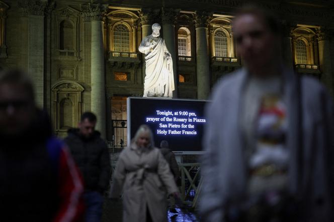 Un écran annonce la tenue d’une prière pour le pape François, sur la place Saint-Pierre, au Vatican, le 24 février 2025.