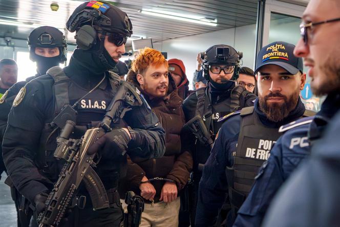 Mohamed Amra, surnommé « la Mouche », escorté par des policiers roumains à l’aéroport international Henri-Coanda, à Otopeni, en Roumanie, le 25 février 2025.