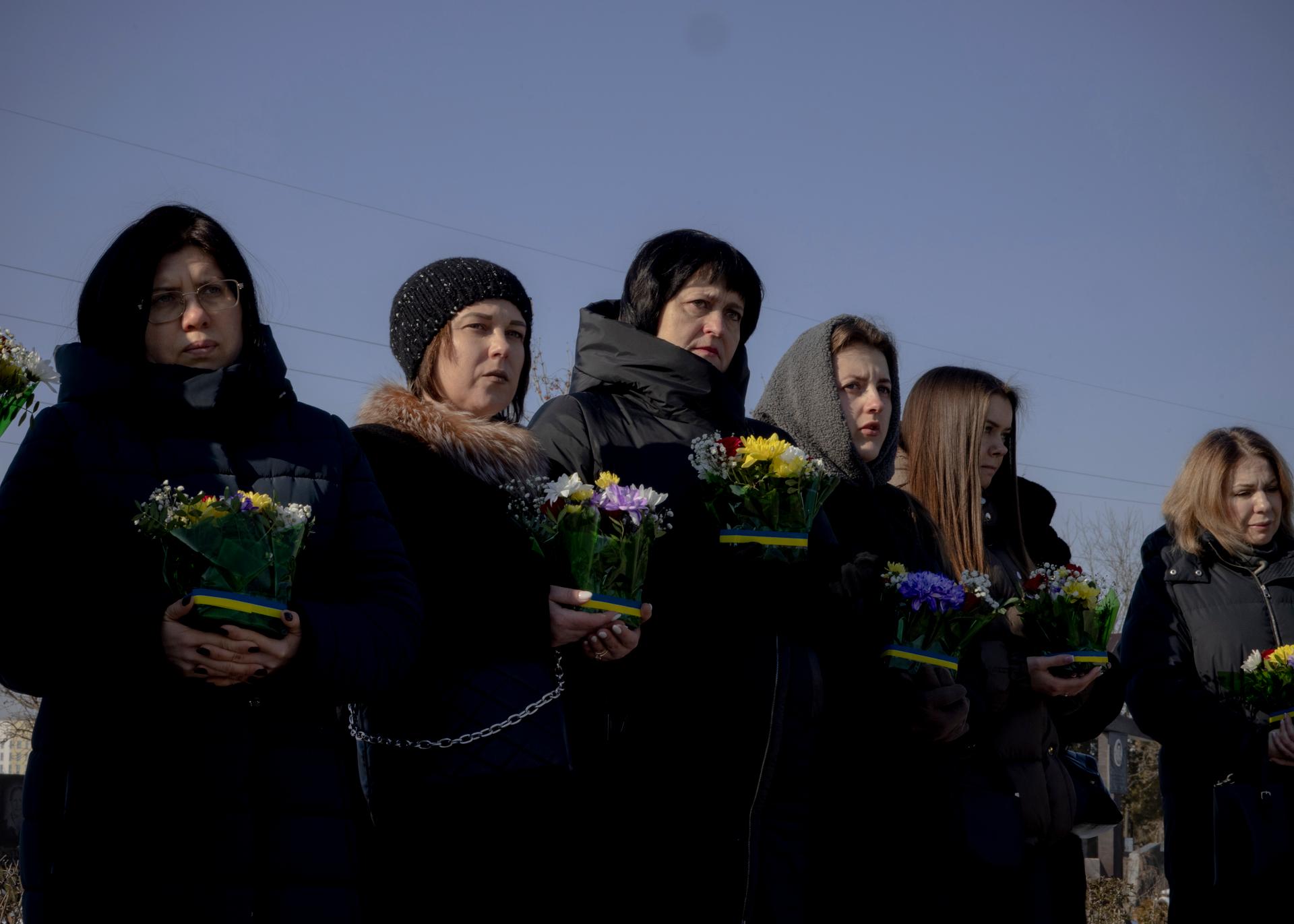 Ukrainian women pay their respects at the Bucha cemetery, Ukraine, February 24, 2025, at a ceremony to commemorate the victims at the outset of the Russian invasion.