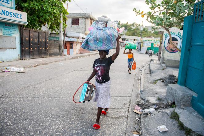 Une femme porte un baluchon sur sa tête alors que les habitants fuient leurs maisons pour échapper à la violence des gangs dans le quartier de Delmas, à Port-au-Prince, en Haïti, le 25 février 2025.