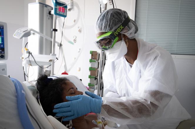 Un membre du personnel médical s’occupe d’un patient de Covid-19 sous assistance respiratoire, dans une chambre du service de soins intensifs du Centre hospitalier universitaire (CHU) Pierre Zobda-Quitman à Fort-de-France, sur l’île française des Caraïbes de la Martinique, le 29 août 2021.