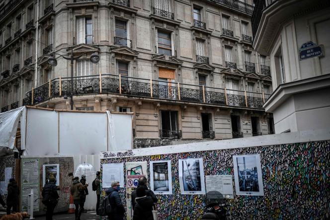 Des personnes regardent des photos lors d’une cérémonie commémorative le 12 janvier 2021 pour marquer les deux ans d’une puissante explosion qui a endommagé un immeuble de la rue de Trévise, dans le centre de Paris.