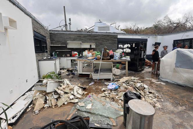 Habitantes de uma casa cujo telhado foi varrido pela Garance Cyclone, em Saint-Benóit, no leste da ilha de reunião, em 1º de março de 2025.