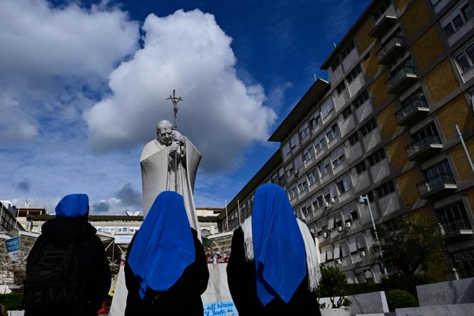 Des religieuses prient devant la statue de Jean Paul II, à l’hôpital Gemelli de Rome, où le pape François est hospitalisé pour une pneumonie, le 28 février 2025.