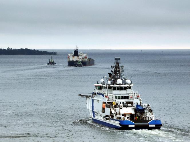 Un navire de la garde frontalière finlandaise escorte, le 2 mars 2025, le pétrolier « Eagle S », immatriculé aux îles Cook soupçonné d’appartenir à la flotte fantôme de la Russie et accusé d’avoir saboté des câbles sous-marins de la Baltique.