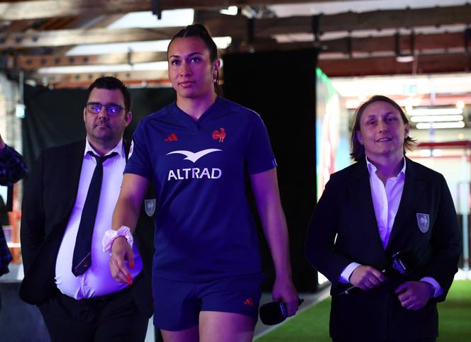 Les cosélectionneurs du XV de France féminin, David Ortiz (à gauche) et Gaëlle Mignot (à droite), entourent la capitaine des Bleues, Manae Feleu, à Londres, le 7 mars 2025.