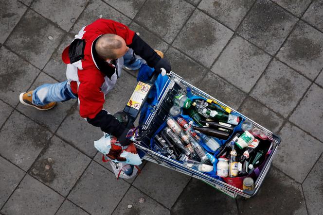 Un homme fait du porte-à-porte avec un chariot rempli de bouteilles en verre qu’il récupère pour la consigne, à Berlin, le 17 janvier 2019.