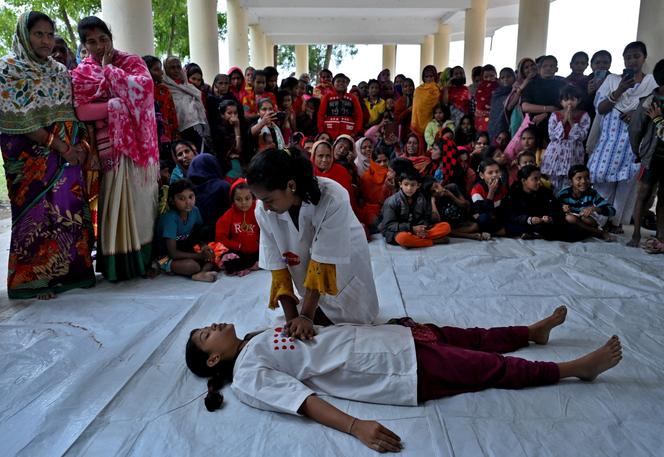 Des volontaires formés par le Fonds des Nations unies pour la population (Fnuap) montrent les techniques de premiers secours lors d’un exercice de préparation au tsunami, dans le village de Kaitha, dans l’Etat oriental d’Odisha, en Inde, en&nbsp;décembre 2024.