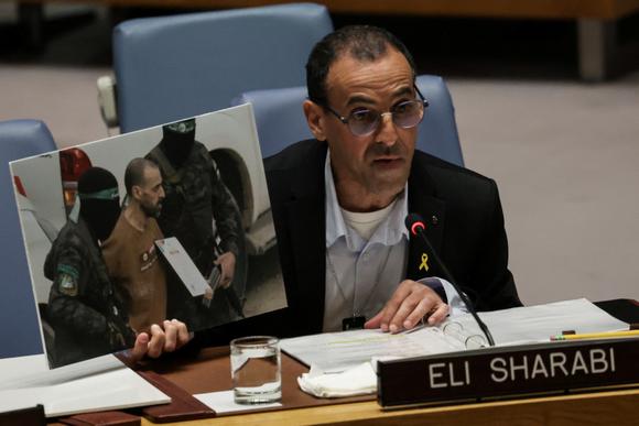 Eli Sharabi, un ancien otage israélien, tient une photo de lui lors de sa libération par le Hamas le mois dernier, alors qu’il s’exprime devant le Conseil de sécurité des Nations unies, à New York, le 20 mars 2025.