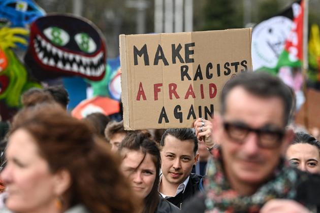 A demonstrator holds a placard reading "Make racists afraid again" during the International Day against Racism and Fascism in Nantes on March 22, 2025. 