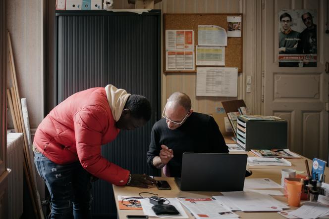 Um trabalhador indocumentado prepara o seu processo de pedido de autorização de residência, com um voluntário da Cimade, em antecipação a uma ação de submissão em grupo. Em Poitiers, 21 de março de 2025.