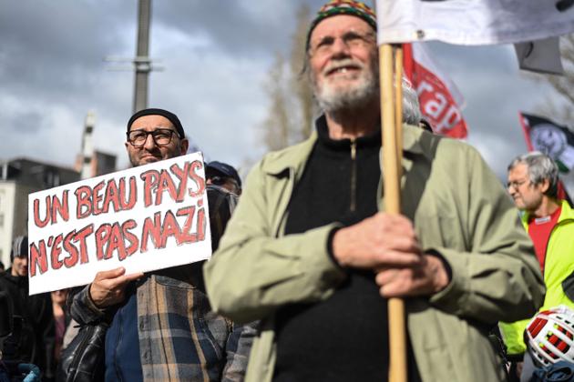 A protestor holds a placard reading "A beautiful country is not nazi" during a rally in Nantes on March 22, 2025.