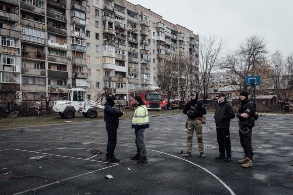 Oleksiy Kliouïev discute avec un policier sur la zone du bombardement de la veille. A Soumy, le 25 mars 2025.