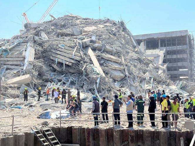 arafed building being demolished by a group of people